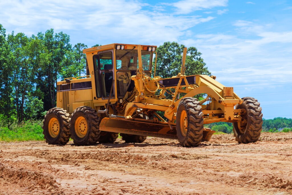 An earthmoving construction grader tractor at a construction site