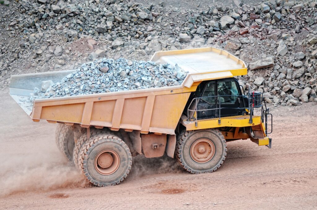 dumper truck driving in an active quarry mine of porphyry rocks. digging